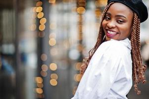 Close up portrait of african american woman in overalls and beret. photo