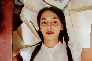 Girl with pigtails in white blouse at old library. photo