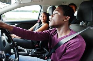 jóvenes amigos afroamericanos sentados dentro de un auto. foto