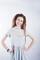 Studio shoot of girl in gray dress with dreads on white background. photo