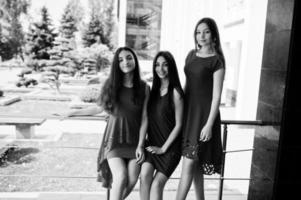 Three teenagers girl in blue and red dresses posed outdoor. photo