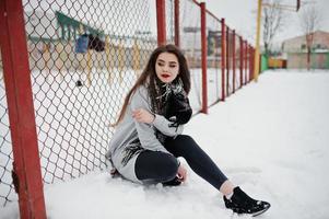 Brunette casual girl in scarf at winter on street. photo