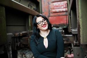 Brunette girl wear in black with glasses in railway station. photo