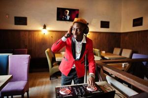 Fashion african american man model DJ at red suit with dj controller. photo