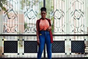 niña afroamericana posó contra puertas de acero al aire libre. foto