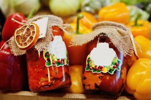 Two roasted pickled canning sweet pepper on jars at the shelf of a supermarket or grocery store. photo