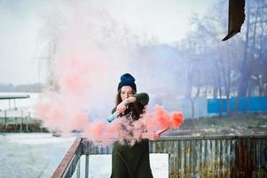 Young girl with blue and red colored smoke bomb in hands. photo