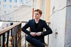 Young stylish macho boy in black jacket posed outdoor of street. Amazing model man. photo