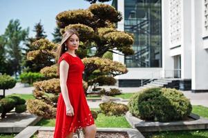 adolescente con vestido rojo posó al aire libre en un día soleado. foto