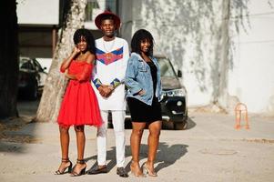 Group of three stylish trendy afro france friends posed at autumn day. Black african man model with two dark skinned womans. photo