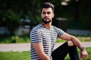 apuesto modelo de hombre de barba árabe alto en camisa despojada planteada al aire libre. chico árabe de moda. foto