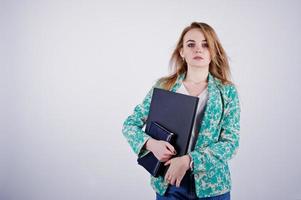 Stylish blonde girl in jacket and jeans with notebook diary and laptop at hands against white background on studio. photo