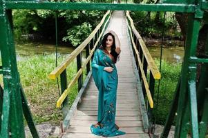 retrato de una hermosa niña brumette india o modelo de mujer hindú en el puente. traje tradicional indio lehenga choli. foto