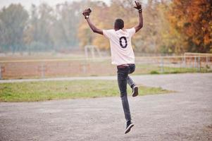 hombre afroamericano en camiseta deportiva de fútbol rosa con número cero. foto