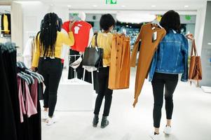 Back of three african woman choosing clothes at store. Shopping day. photo