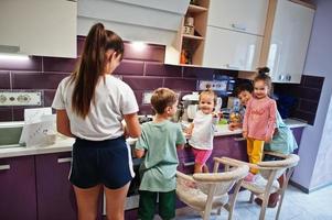 madre con hijos cocinando en la cocina, momentos felices de los niños. foto