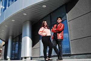 Asian couple standing together against new modern building. photo