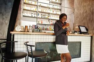 African american businesswoman drinking cocktail lemonade in cafe at the bar. Black girl having rest. photo