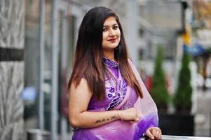 Indian hindu girl at traditional violet saree posed at street. photo