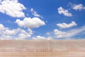brown wood table top on bokeh abstract blue sky background - can be used for montage or display your products photo
