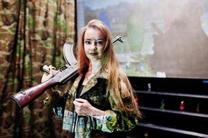 Girl with machine gun at hands on shooting range. photo