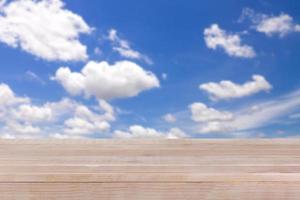 brown wood table top on bokeh abstract blue sky background - can be used for montage or display your products photo