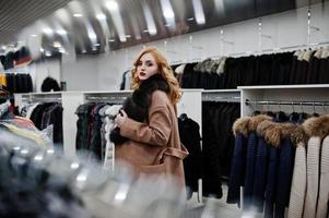 chica rubia de elegancia en abrigo de piel en la tienda de abrigos de piel y chaquetas de cuero. foto