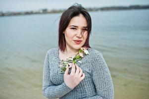 retrato de una chica morena con vestido gris de fondo el lago. foto