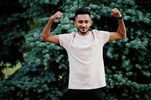 el hombre elegante de la barba india muestra su mano muscular. modelo india posó en el jardín verde de la ciudad. foto