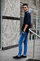 Stylish indian model man in casual clothes and sunglasses posed outdoor at street of India. photo