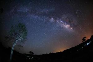 Milky Way Galaxy and Silhouette of Tree with cloud.Long exposure photograph.With grain photo