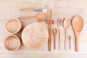 Various wooden kitchen utensils on wood table. top view photo