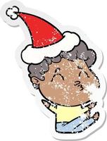 distressed sticker cartoon of a man pouting wearing santa hat vector