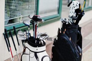 Many golf clubs in bag at pavement. photo