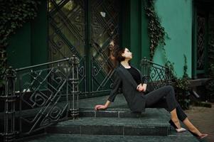 una mujer modelo hermosa y elegante joven de piernas largas en ropa formal posó en las escaleras. foto