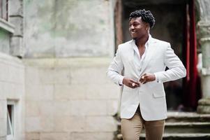 Thoughtful young handsome african american gentleman in formalwear. Black stylish model man in white jacket. photo