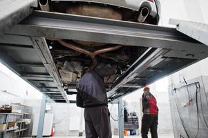 Auto mechanic sets american SUV car for diagnostics and configuration camber check in workshop of service station.. photo