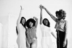 Four best friends. Young adrican women having fun and spend time together, stacking hands and then up. photo