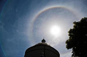 Fantástico y hermoso fenómeno de halo de sol en la iglesia, arco iris circular. foto