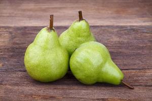 fresh green pears on old wooden table photo