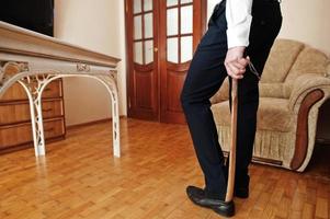 Man puts on classic black shoes with a wooden shoe spoon. photo