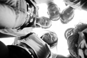 Group of five african college students spending time together on campus at university yard. Black afro friends studying. Education theme. View from down. photo