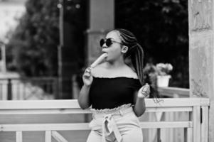 Stylish african american woman at sunglasses with ice cream. photo