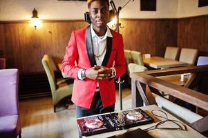 Fashion african american man model DJ at red suit with dj controller. photo