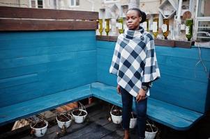 African woman in checkered cape posed outdoor. photo