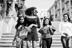 Group of four african american girls walking at stairs of city. photo