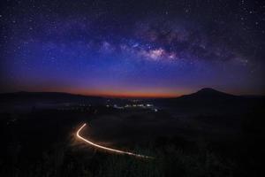 Milky way galaxy with lighting on the road at Khao Takhian Ngo View Point at Khao-kho Phetchabun,Thailand, Long exposure photograph photo
