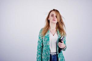 Stylish blonde girl in jacket and jeans with notebook diary at hands against white background on studio. photo