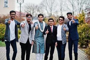 Group of six south asian indian mans in traditional, casual and business wear standing and  shows thumb up. photo