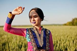 Tender indian girl in saree, with violet lips make up posed at field in sunset. Fashionable india model. photo